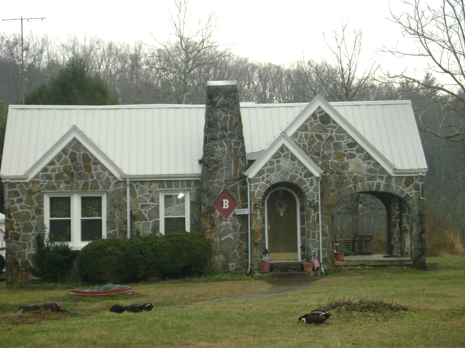 White metal roof on a stone cottage with steep gables in Burden