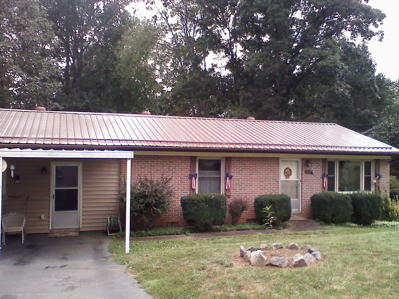 Bronze metal roof and carport on a brick ranch home — Roof Repair work by our crew in Burden